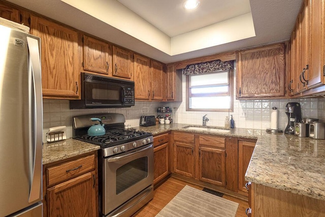 kitchen with decorative backsplash, stainless steel appliances, and a sink