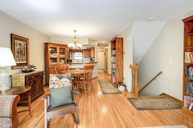 dining area featuring light wood finished floors and a notable chandelier