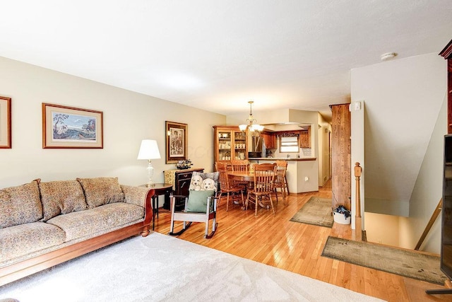 living area with light wood-style floors and a notable chandelier