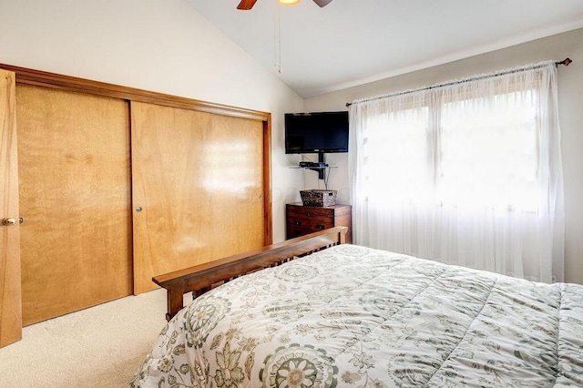 bedroom featuring a closet, vaulted ceiling, carpet floors, and ceiling fan