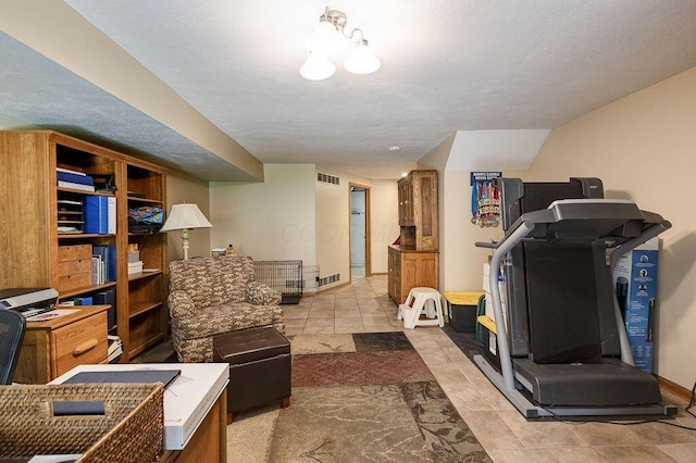 workout room featuring tile patterned floors, baseboards, visible vents, and a textured ceiling