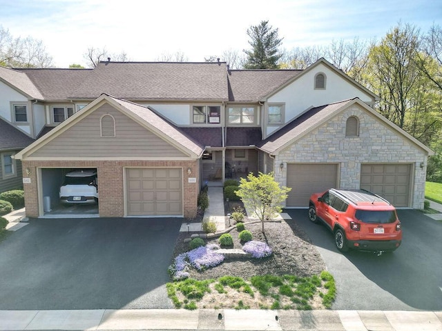 view of front of property with brick siding, aphalt driveway, stucco siding, and a garage