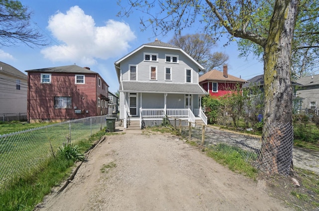 traditional style home with a porch, fence, and driveway