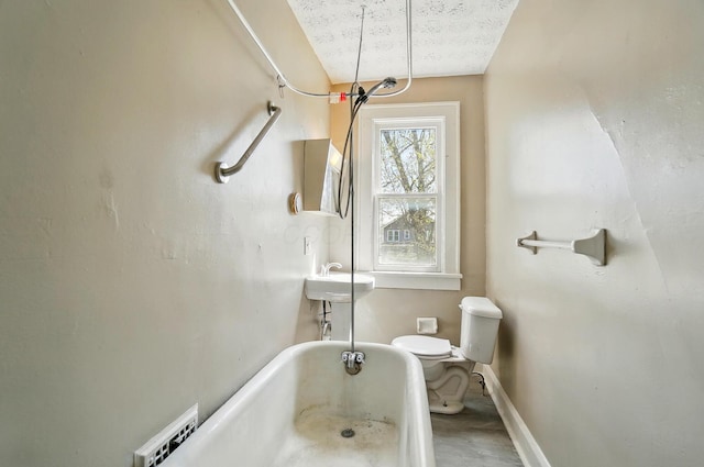 full bathroom with a sink, a bathing tub, toilet, baseboards, and visible vents