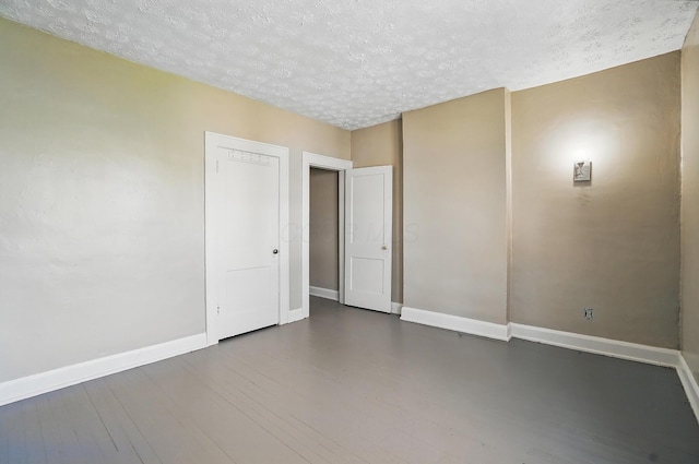 empty room with baseboards and a textured ceiling