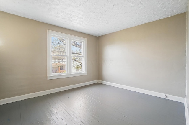 unfurnished room featuring dark wood-style flooring, baseboards, and a textured ceiling