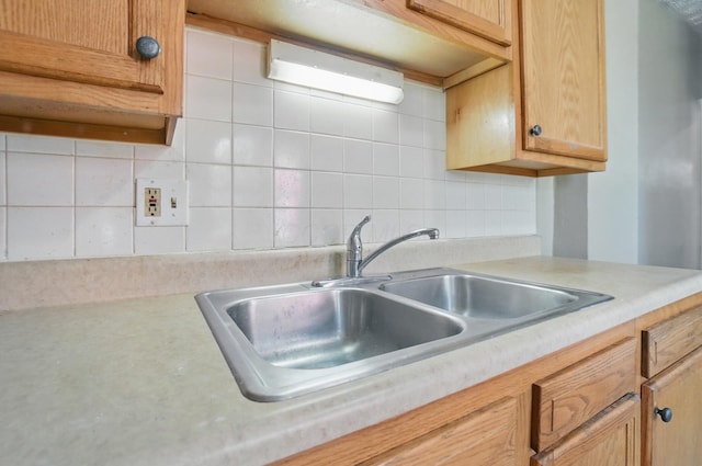 kitchen with light countertops, a sink, and tasteful backsplash