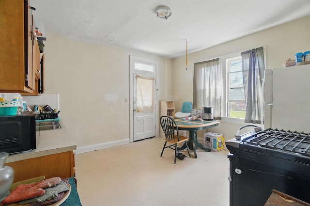 dining space with baseboards, light floors, and a wealth of natural light