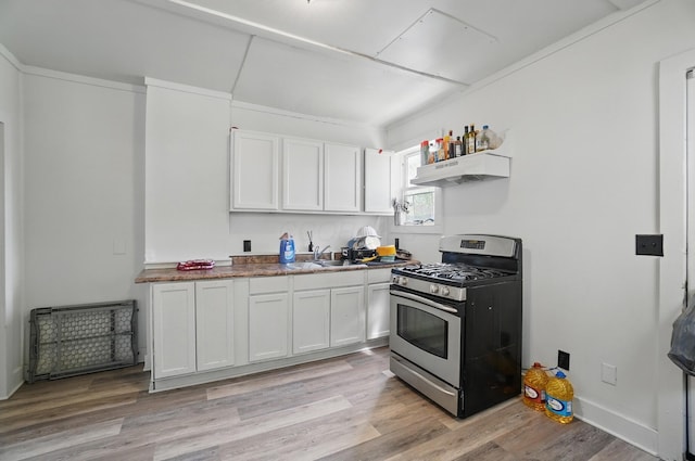 kitchen with stainless steel range with gas cooktop, white cabinetry, under cabinet range hood, a sink, and light wood-style flooring