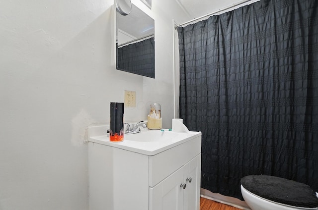 full bath featuring vanity, wood finished floors, and toilet