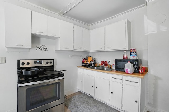 kitchen with white cabinets, black microwave, a sink, light countertops, and electric stove