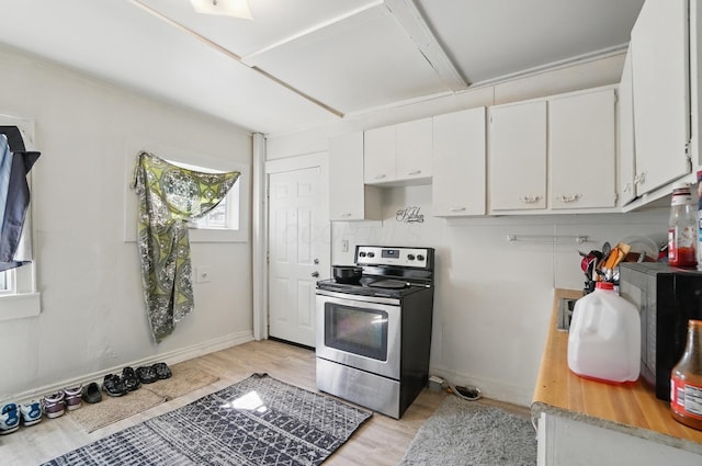 kitchen with baseboards, light wood-type flooring, light countertops, white cabinets, and stainless steel range with electric cooktop