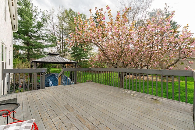 wooden terrace with a lawn and a gazebo