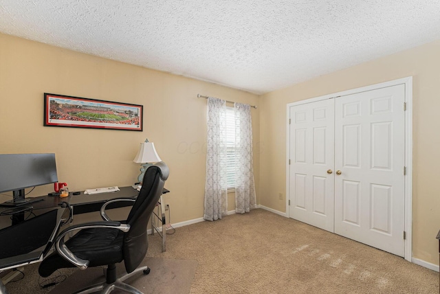 office space featuring carpet floors, a textured ceiling, and baseboards