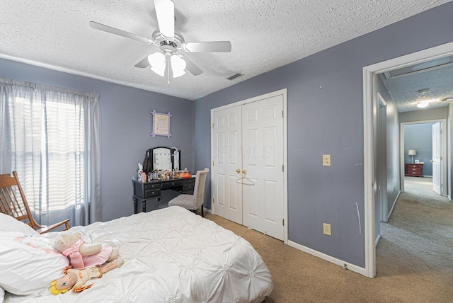 bedroom featuring carpet, visible vents, a closet, attic access, and a textured ceiling