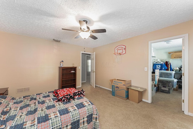bedroom with a textured ceiling, ceiling fan, light colored carpet, baseboards, and visible vents