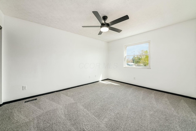 empty room with baseboards, ceiling fan, and carpet