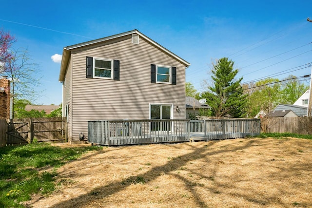 back of property with a wooden deck and a fenced backyard