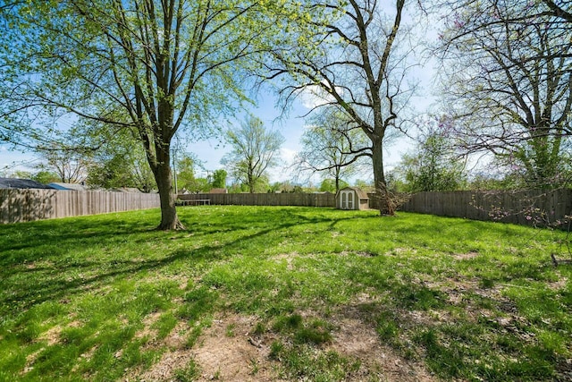 view of yard featuring an outbuilding, a shed, and a fenced backyard