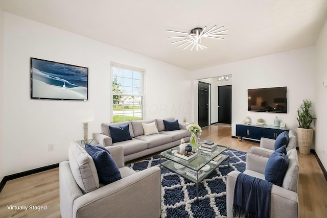 living room with baseboards, wood finished floors, and a chandelier
