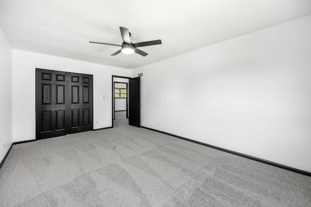 unfurnished bedroom featuring carpet floors, ceiling fan, a closet, and baseboards