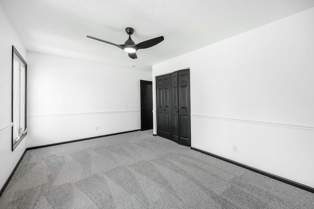 unfurnished bedroom featuring baseboards, a ceiling fan, a closet, and carpet flooring