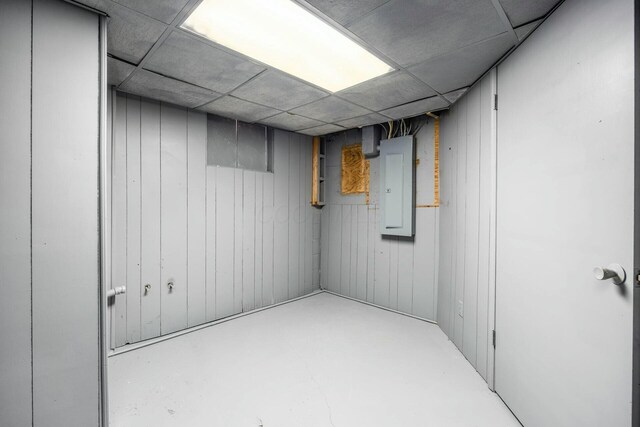 finished below grade area featuring electric panel and a paneled ceiling