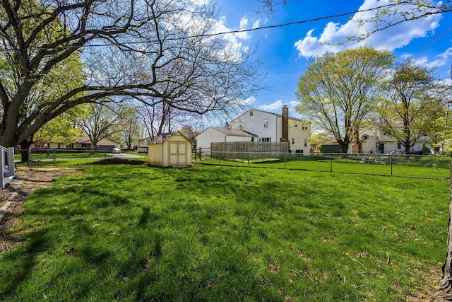 view of yard with an outbuilding, a storage unit, a residential view, and a fenced backyard