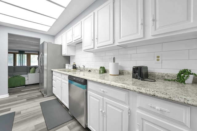 3236 Donalda Ct, Columbus, OH 43231 - kitchen with appliances with stainless steel finishes, a sink, white cabinets, backsplash, and light wood finished floors