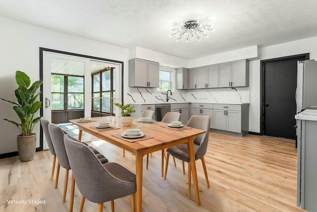 dining area featuring light wood finished floors and a chandelier