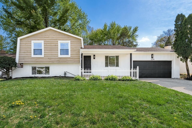 split level home with a garage, a chimney, a front lawn, and concrete driveway