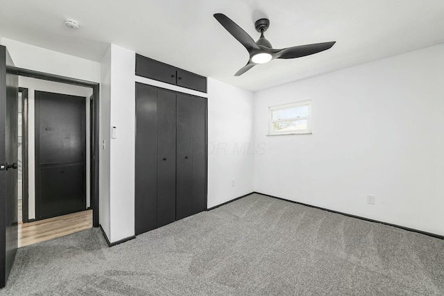 unfurnished bedroom featuring a closet, a ceiling fan, carpet floors, and baseboards