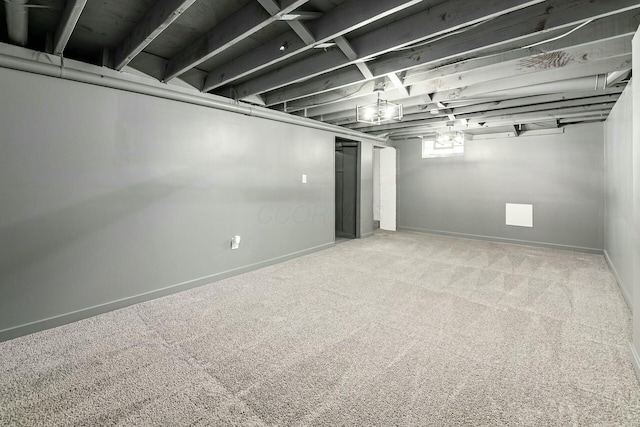 basement featuring carpet flooring and baseboards