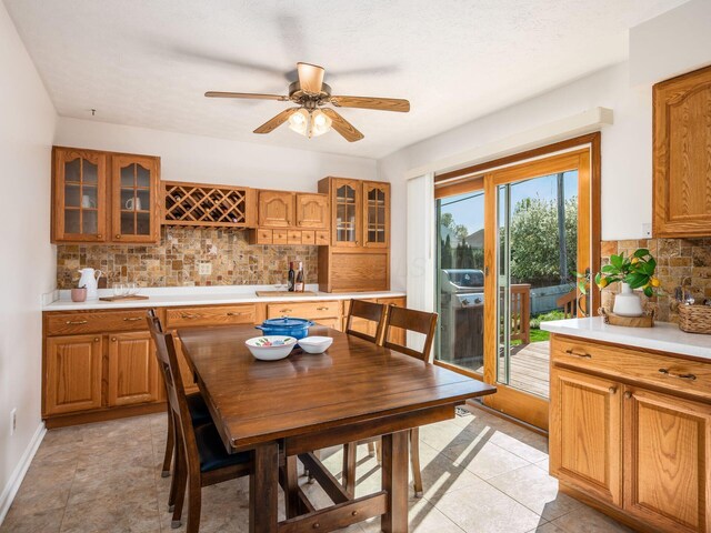 dining room with ceiling fan, baseboards, and indoor bar
