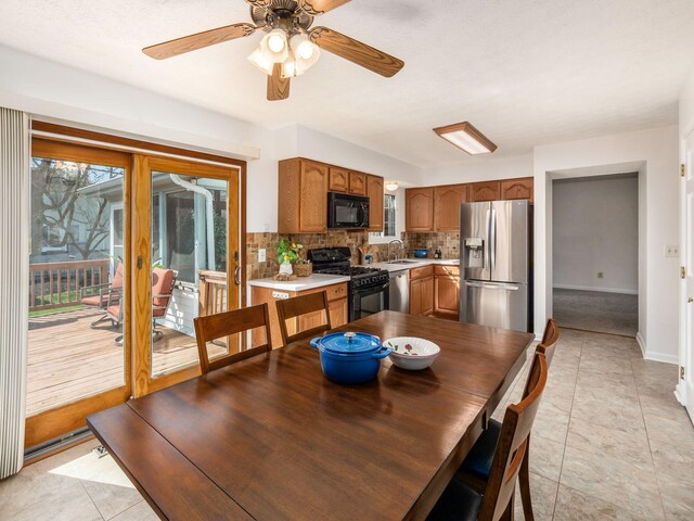 dining room featuring baseboards, a ceiling fan, and light tile patterned floors