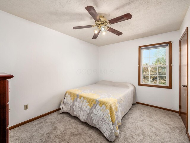 bedroom featuring carpet, a textured ceiling, and baseboards