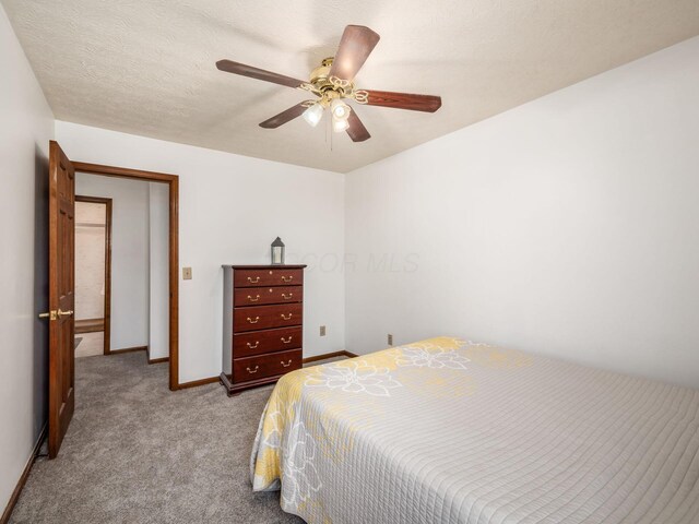 carpeted bedroom with a ceiling fan and baseboards