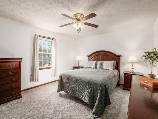 bedroom with light carpet, a ceiling fan, baseboards, and a textured ceiling