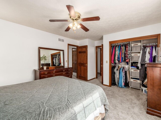 bedroom with ceiling fan, carpet flooring, visible vents, and a closet