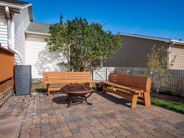 view of patio with a gate, fence, cooling unit, and an outdoor fire pit