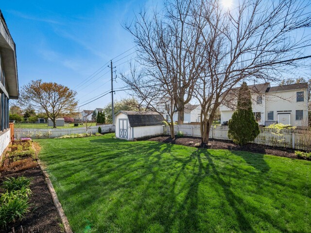 view of yard featuring a fenced backyard, an outdoor structure, and a storage shed