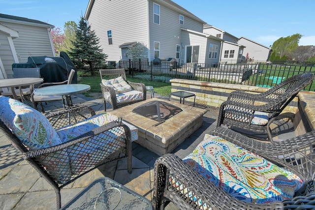 view of patio featuring fence, grilling area, and an outdoor living space with a fire pit