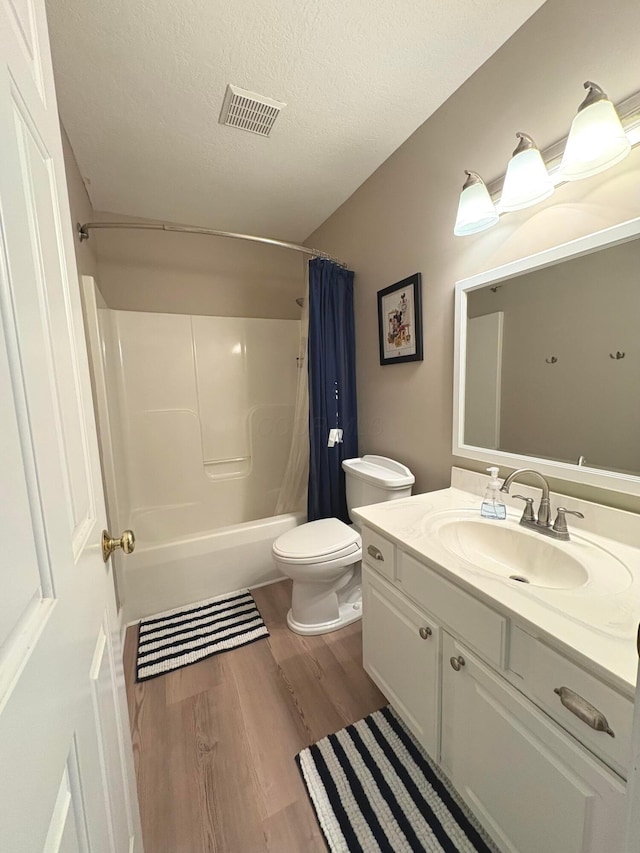 33 Hampden Dr, Granville, OH 43023 - bathroom featuring wood finished floors, toilet, shower / bath combination with curtain, vanity, and a textured ceiling