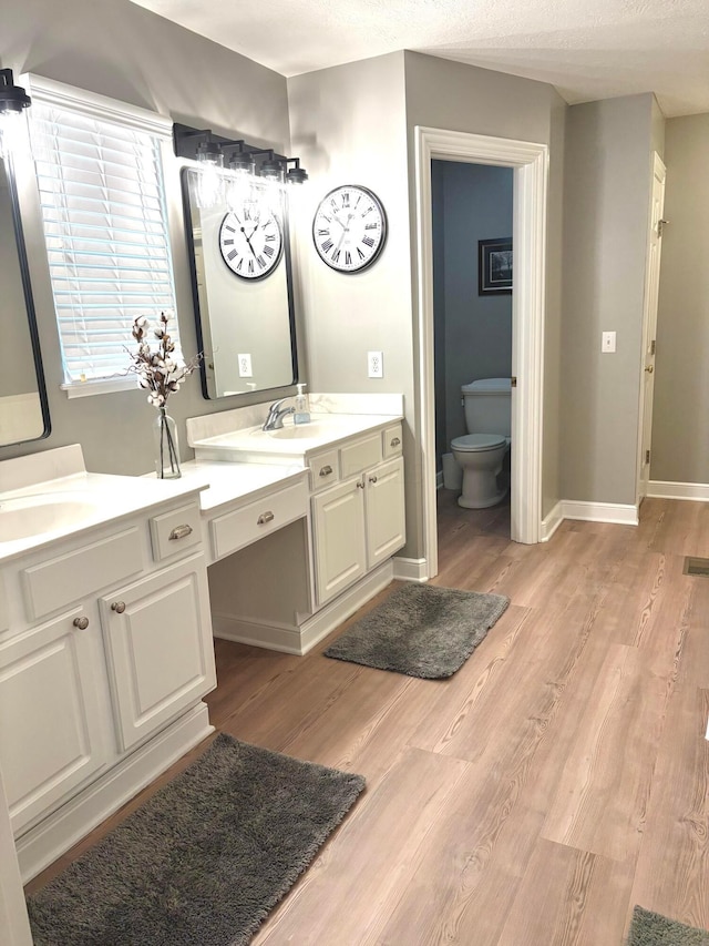 33 Hampden Dr, Granville, OH 43023 - full bathroom featuring wood finished floors, double vanity, toilet, and baseboards