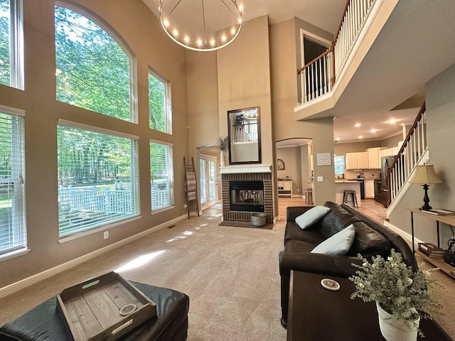 33 Hampden Dr, Granville, OH 43023 - living room with light carpet, a brick fireplace, a high ceiling, baseboards, and stairway