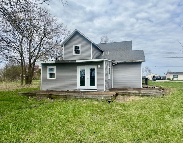 back of property with a wooden deck, french doors, and a lawn