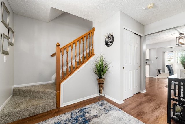 entryway with baseboards, wood finished floors, and stairs