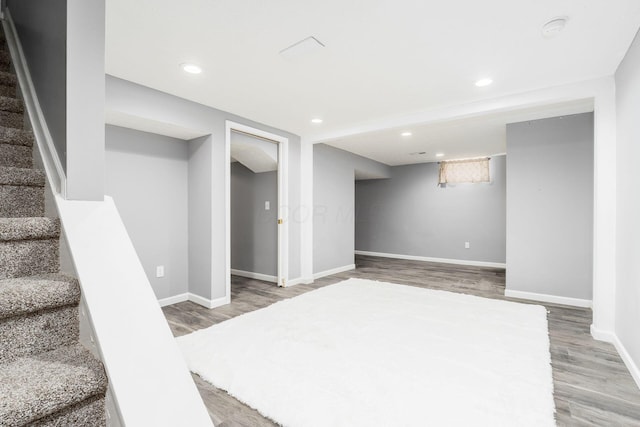 finished basement with recessed lighting, wood finished floors, baseboards, and stairway