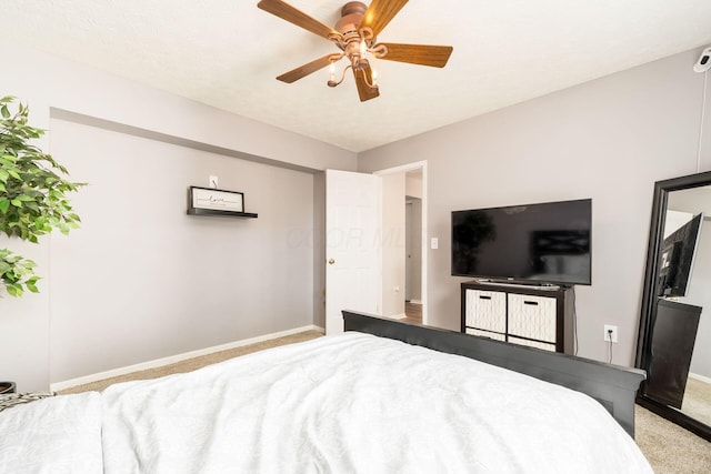 bedroom featuring light colored carpet, ceiling fan, and baseboards