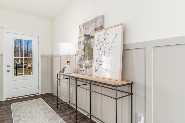 doorway with dark wood-style floors and wainscoting
